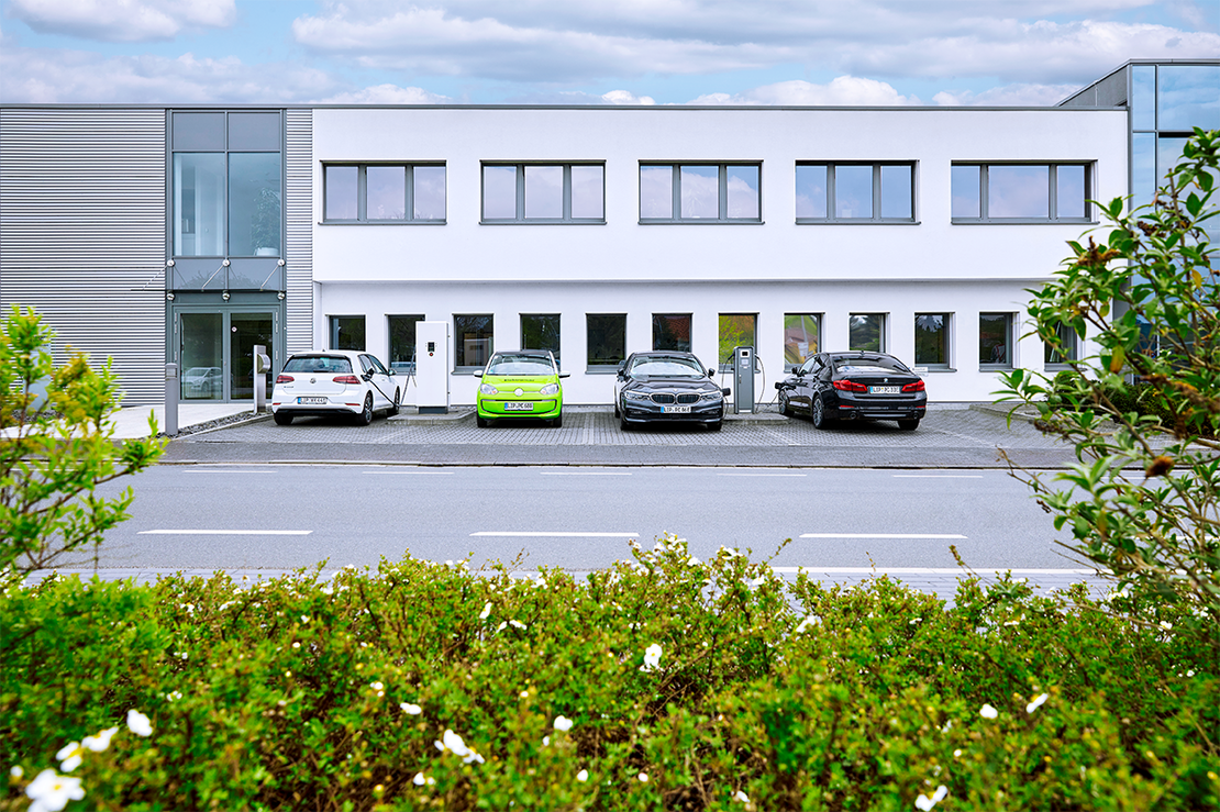 Charge Repay Service Autos vor Bürogebäude